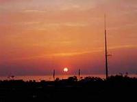 沈む夕日と街並みのシルエットの写真