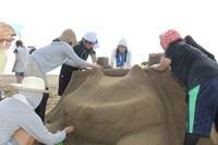グループで熱心に砂像作りに励む学生
