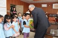 辻角副市長にお花を手渡す園児の写真