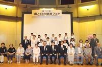 コスモアイル羽咋の会場でハチマルニイマル運動の受賞者、小学生から年配者29人が3列になって記念撮影している写真
