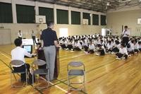 羽咋工業高校の講堂で1人の生徒が起立して講師に質問している写真