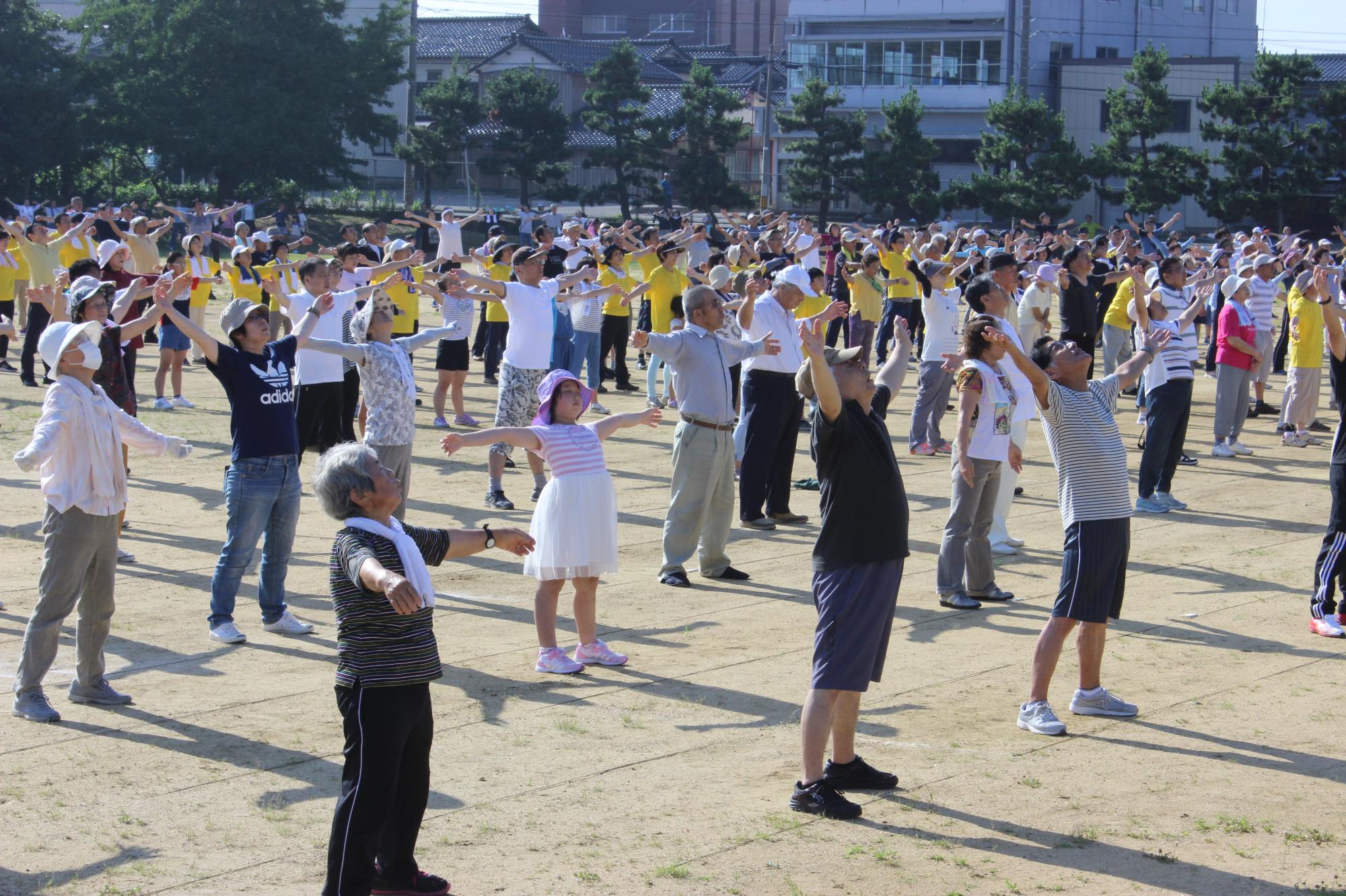 羽咋小学校グラウンドで、大勢の参加者がラジオ体操で汗を流しました