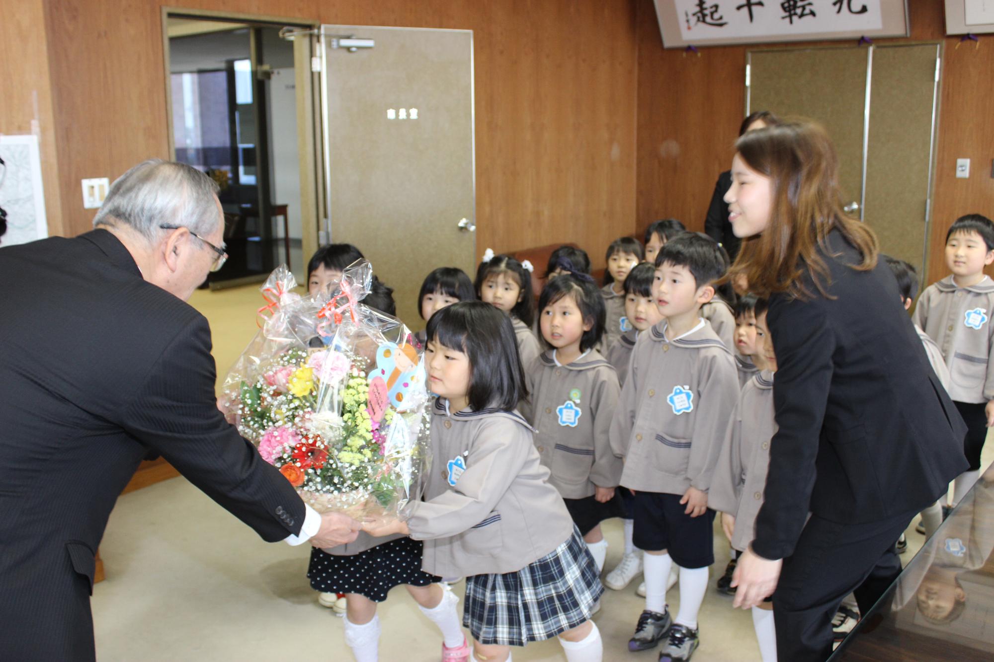 園児の代表2人が山辺市長に花束を手渡す