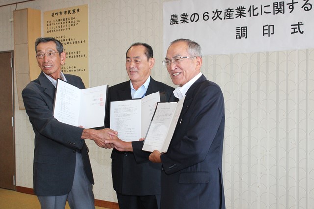 前田部会長、中村組合長、山辺市長が手を取り合って、合意を喜びました