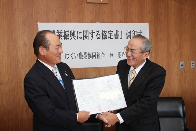 協定を締結し、笑顔で握手を交わす中村清長組合長（左）と山辺市長