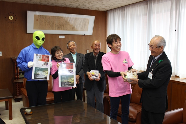 辻角副市長にCDを渡す新屋敷さんとチーム柴垣のメンバー