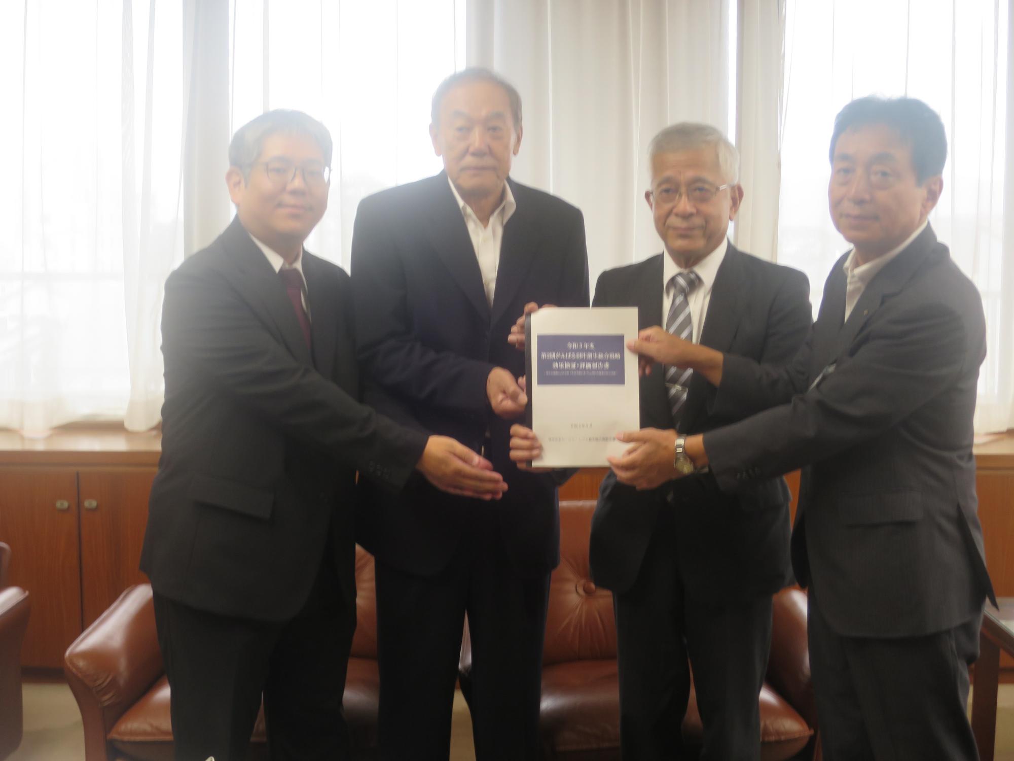 岸市長（右）に効果検証報告書を手渡した、羽咋市まち・ひと・しごと創生総合戦略会議の関係者